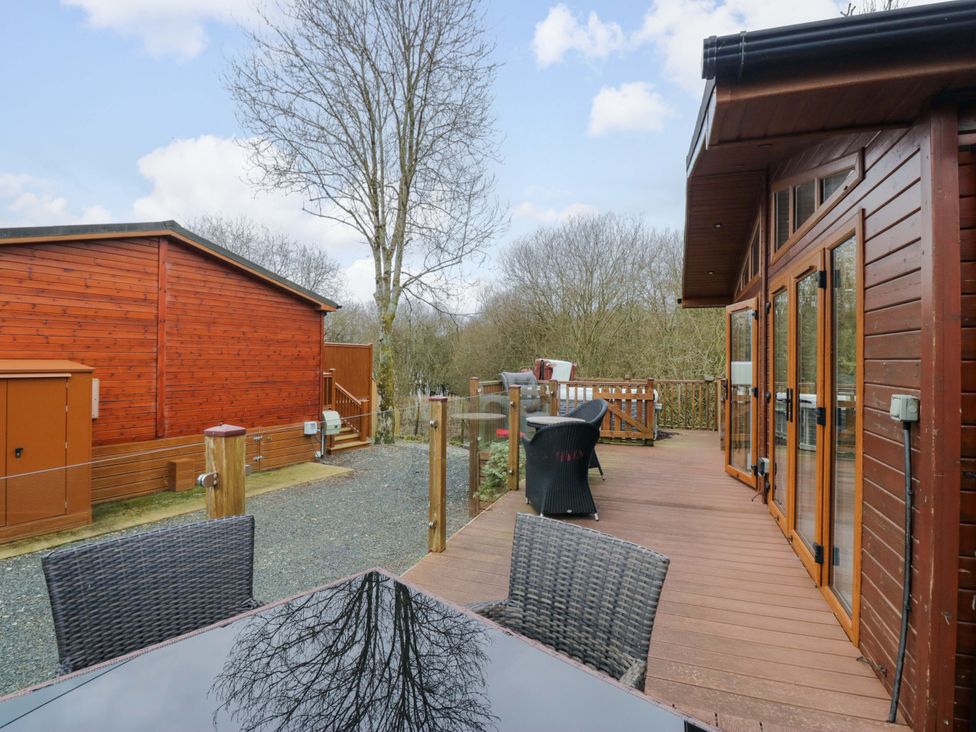 An outdoor area with a deck and wooden lodge at Waters Edge Lodge Windermere