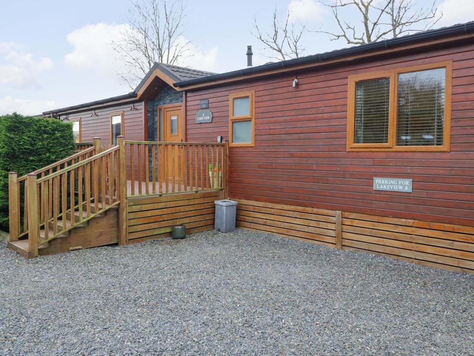 An outdoor area with a wooden lodge and parking sign at Waters Edge Lodge Windermere