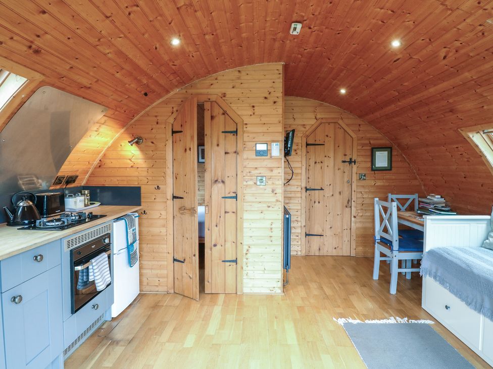 A kitchen with cabinets and dining area at Vine View near Halesworth