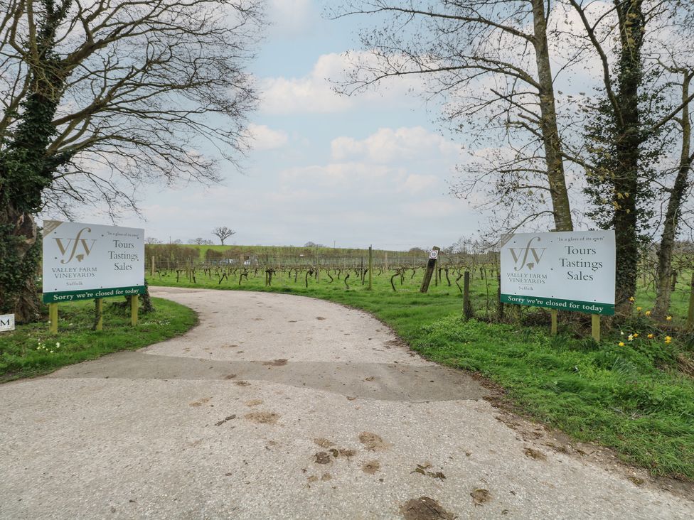 An entrance to Valley Farm Vineyards with signs showing Tours, Tastings, and Sales near Halesworth