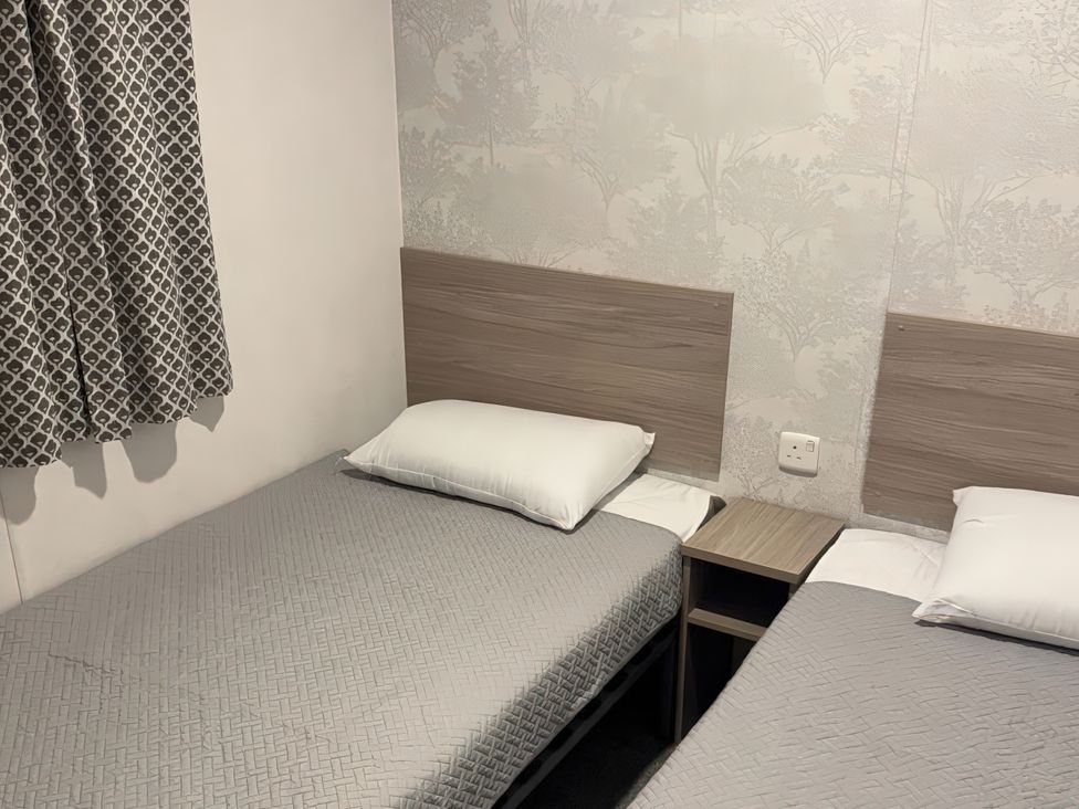 A bedroom with two beds and a nightstand at N5 Ilfracombe