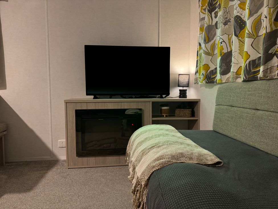 A living room with a television and sofa at N5 in Ilfracombe