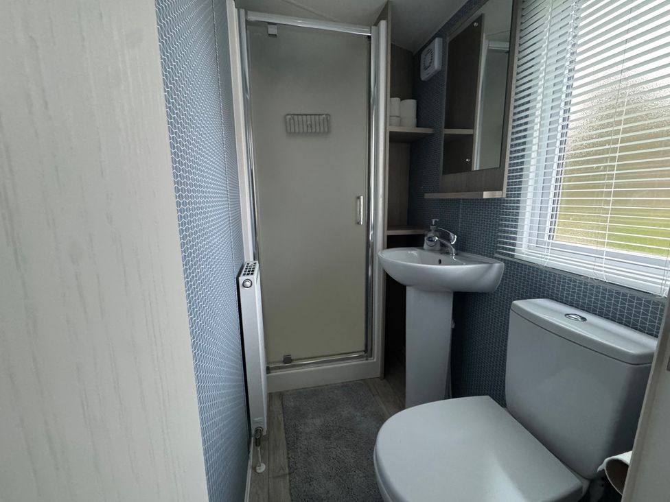 A bathroom with a shower, wash basin, and toilet at N5 in Ilfracombe