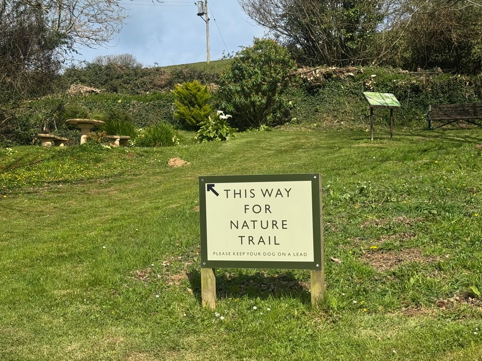 A sign directing to nature trail with a bench in the garden at N5 Ilfracombe