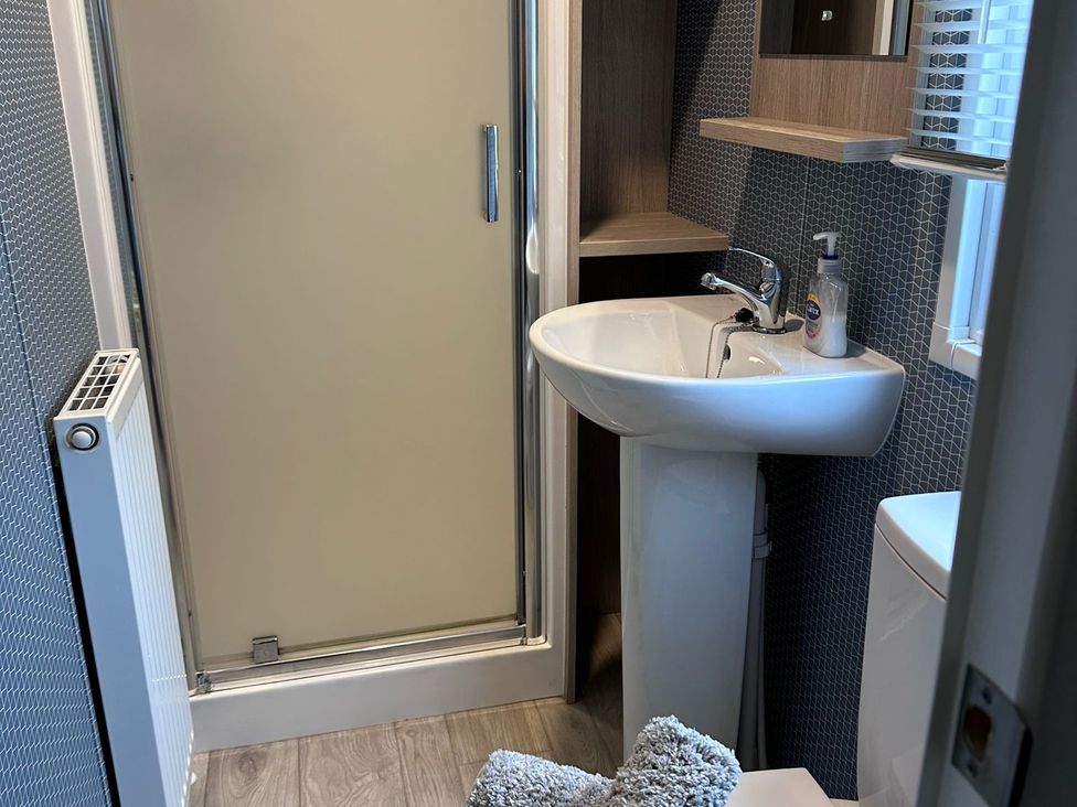 A bathroom with a shower, sink, and toilet at N5 Ilfracombe