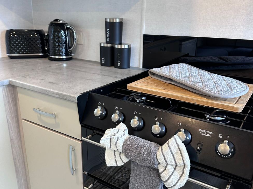 A kitchen with appliances and storage containers at N5 Ilfracombe