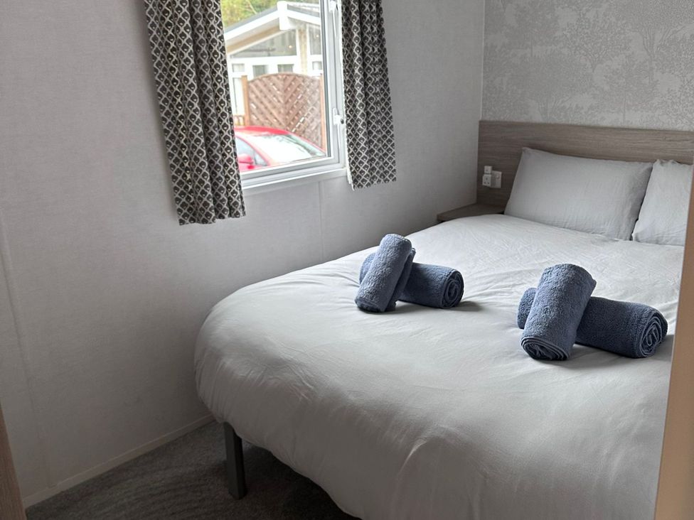 A bedroom with a double bed and towels at N5 in Ilfracombe