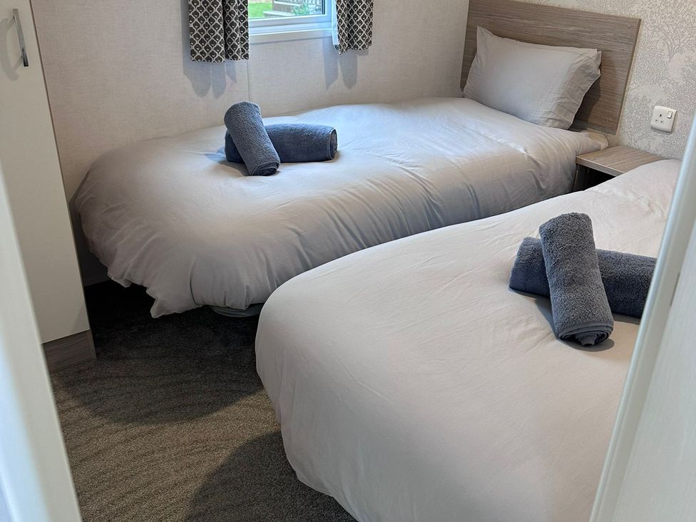 A bedroom with two beds and towels on top at N5 in Ilfracombe