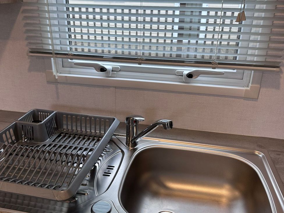 A kitchen sink with a faucet and draining rack at N5 Ilfracombe