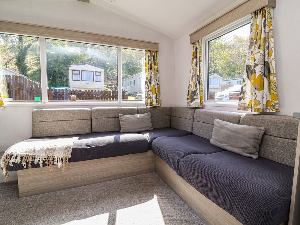 A snug room with a sofa and windows at N5 Ilfracombe