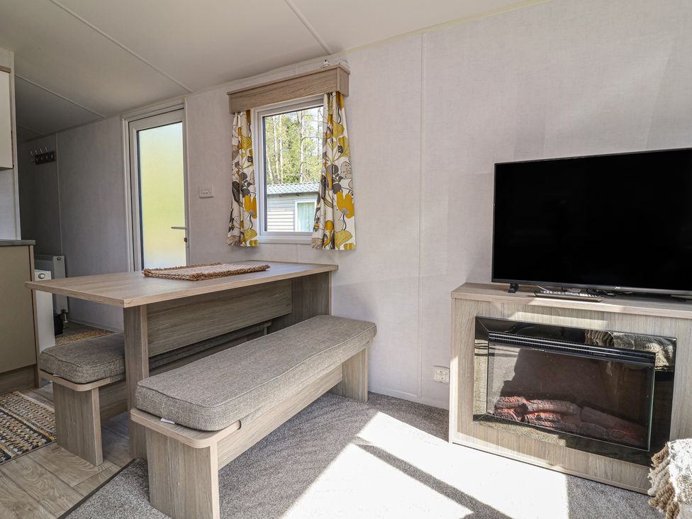 A dining area with a table and bench at N5 Ilfracombe