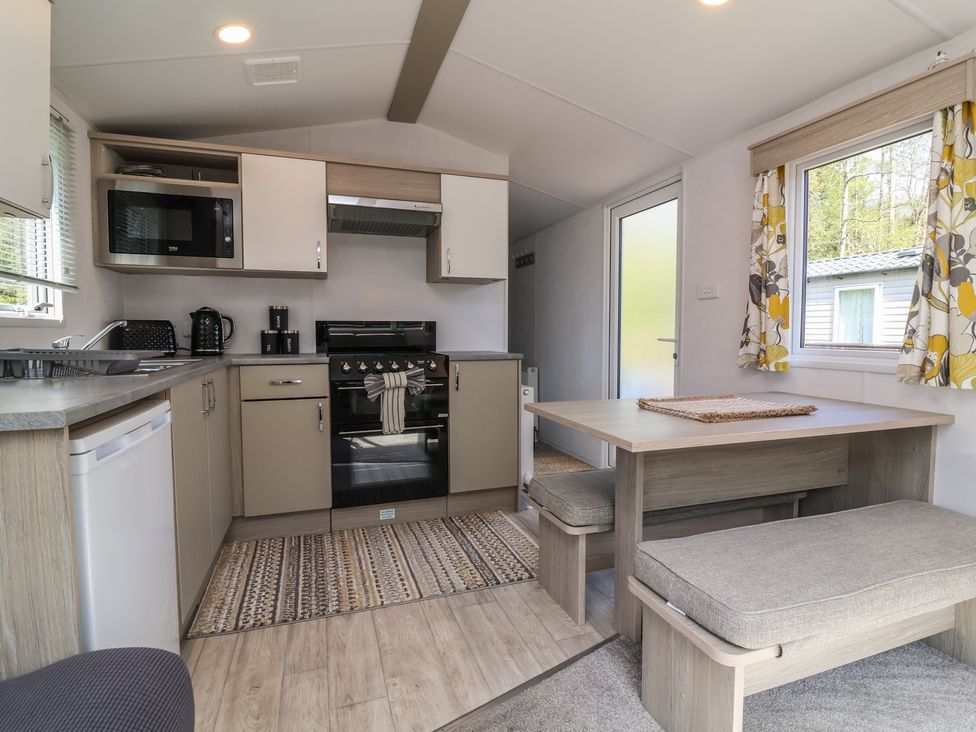A kitchen with appliances and dining area at N5 Ilfracombe