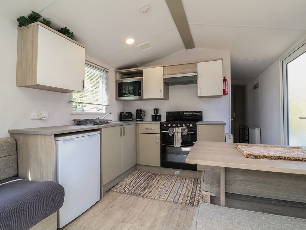 A kitchen with appliances and dining space at N5 Ilfracombe