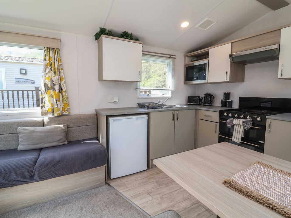 A kitchen with appliances and a seating area at N5 Ilfracombe