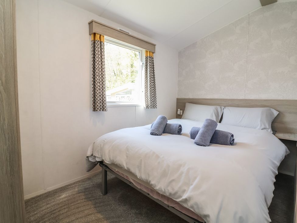 A bedroom with a double bed and towels arranged on it at N5 in Ilfracombe