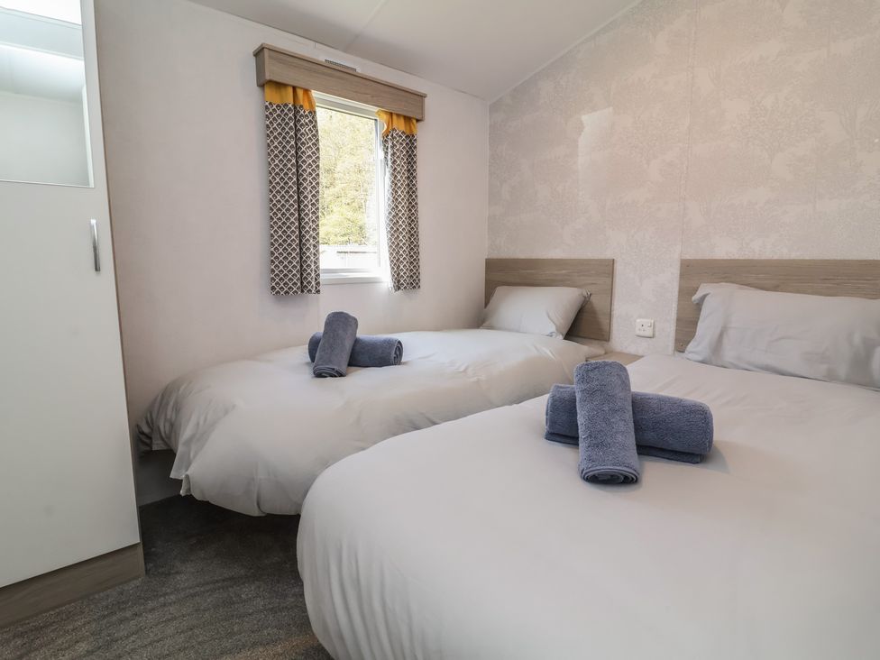 A bedroom with two beds and towels at N5 Ilfracombe