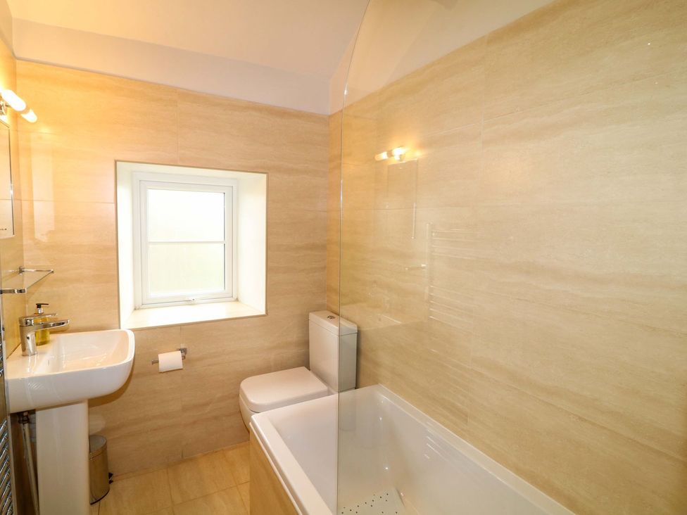 A bathroom featuring a bath tub, toilet, and sink at The Annexe in Belper