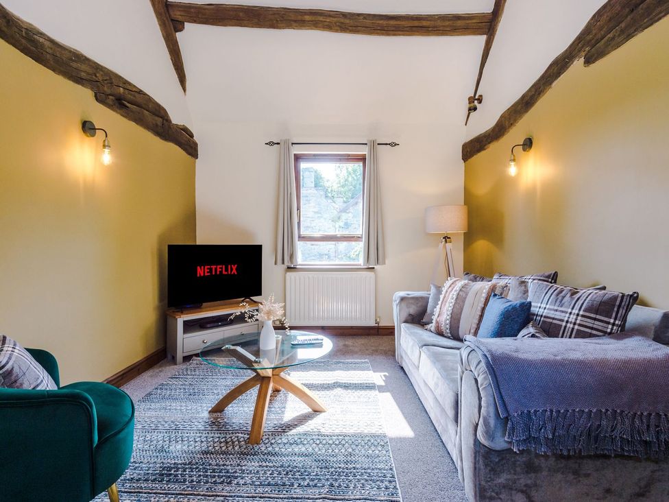 A living room with a sofa and a television at Idris Barn