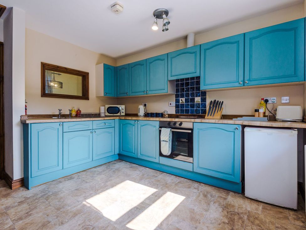 A kitchen with blue cabinets and appliances at Idris Barn in 