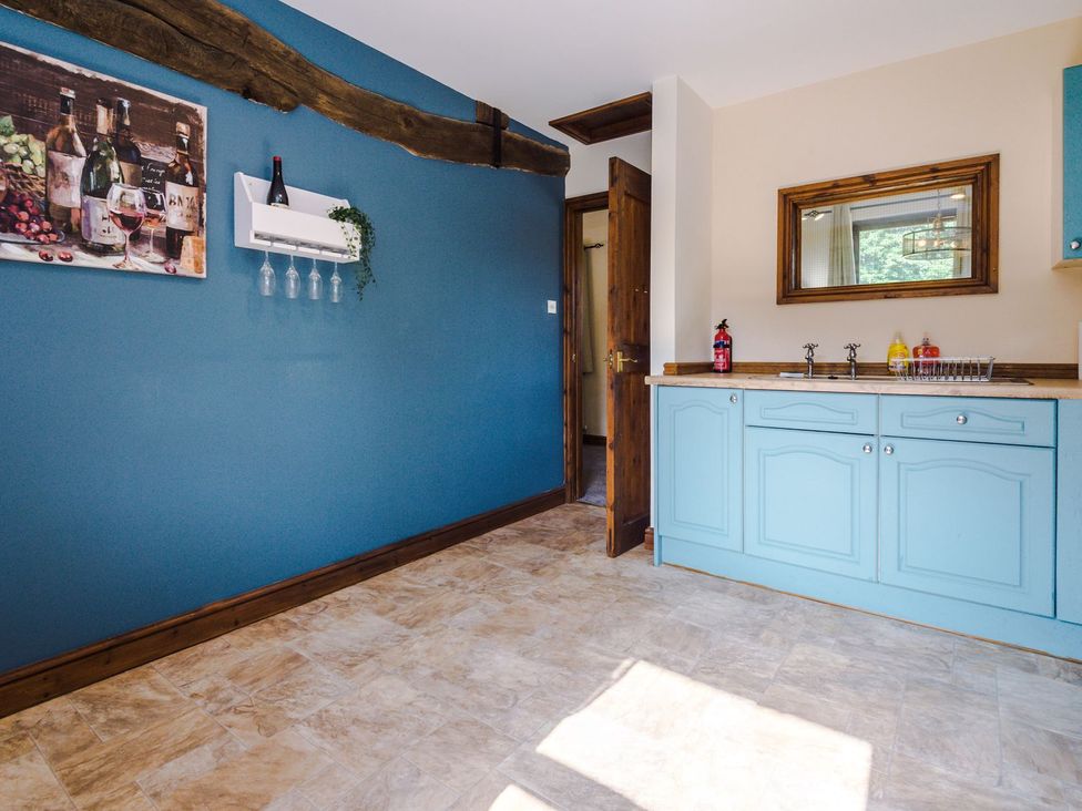 A kitchen with blue cabinets and a mirror at Idris Barn in 