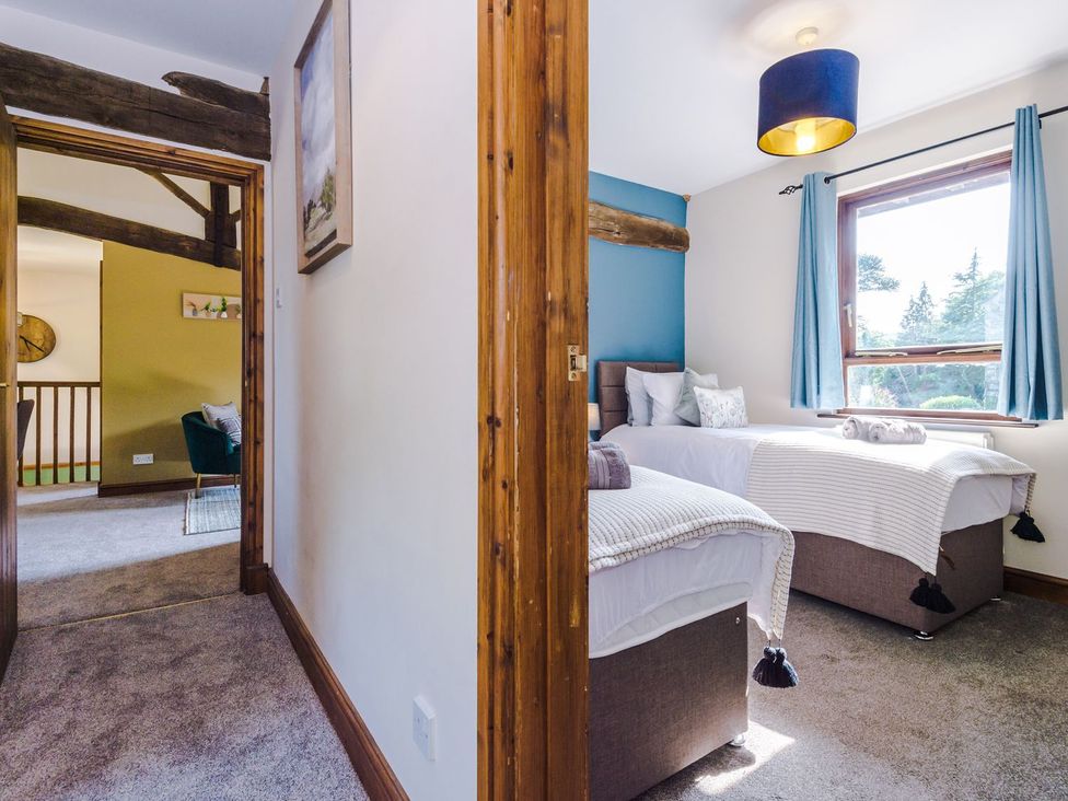 A bedroom with two beds and a window at Idris Barn
