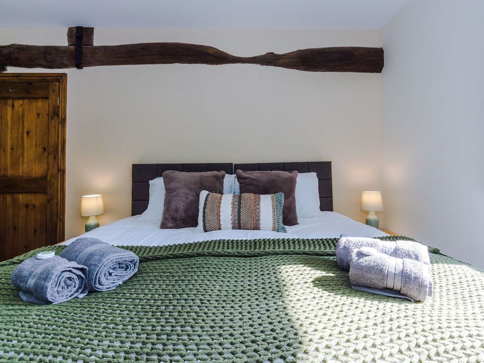A bedroom with a bed and side lamps at Idris Barn