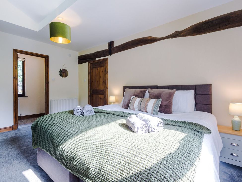 A bedroom with a bed, towels, lamp and window at Idris Barn 