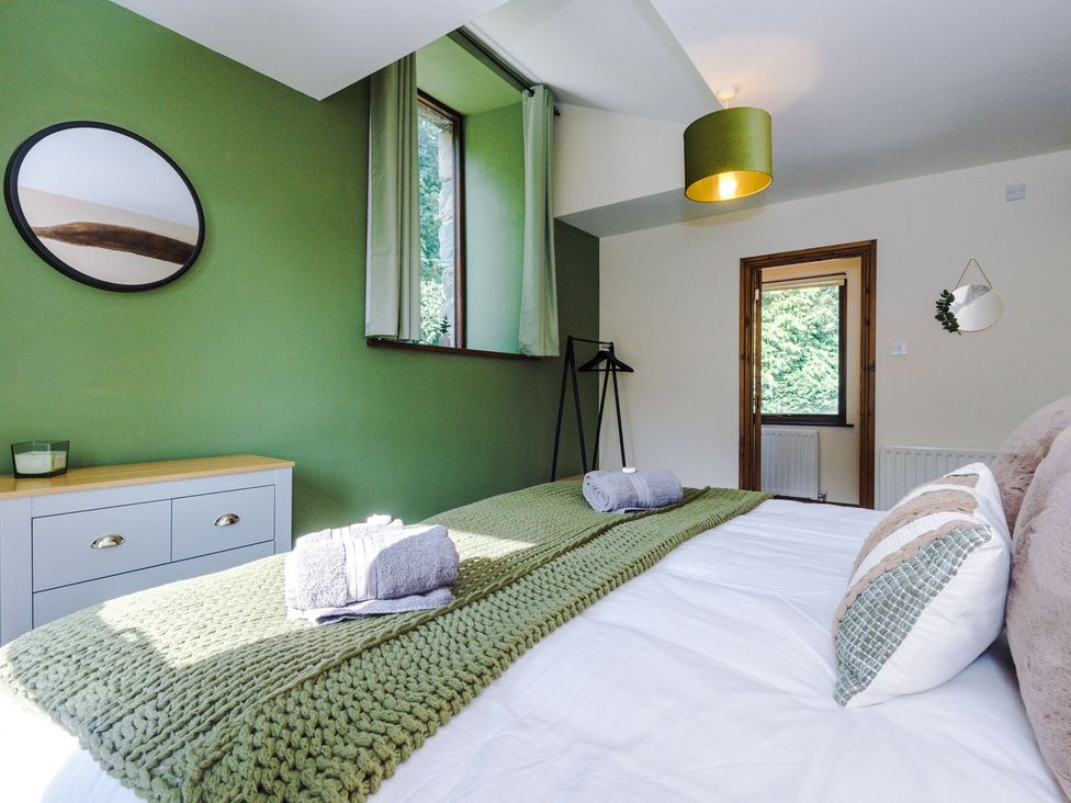 A bedroom with a bed and green walls at Idris Barn in 