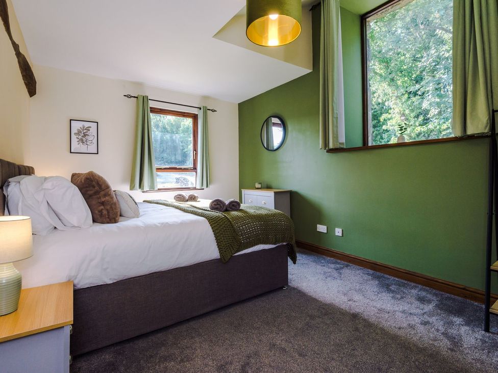A bedroom with a bed and windows at Idris Barn