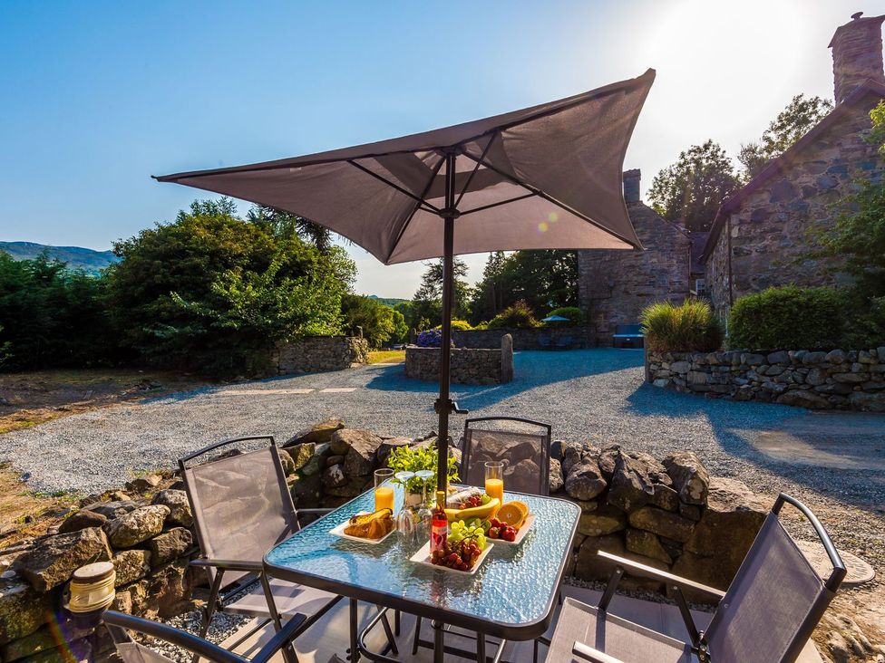 An outdoor seating area with a table and umbrella at Idris Barn