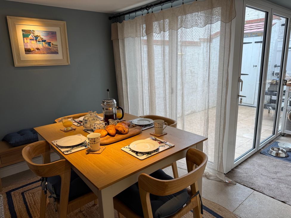 A dining room with a table set for breakfast at York Cottage in Southwold