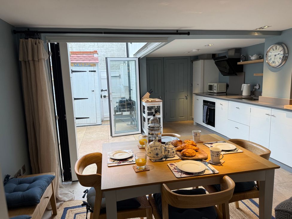 A kitchen with a dining table set for breakfast at York Cottage Southwold