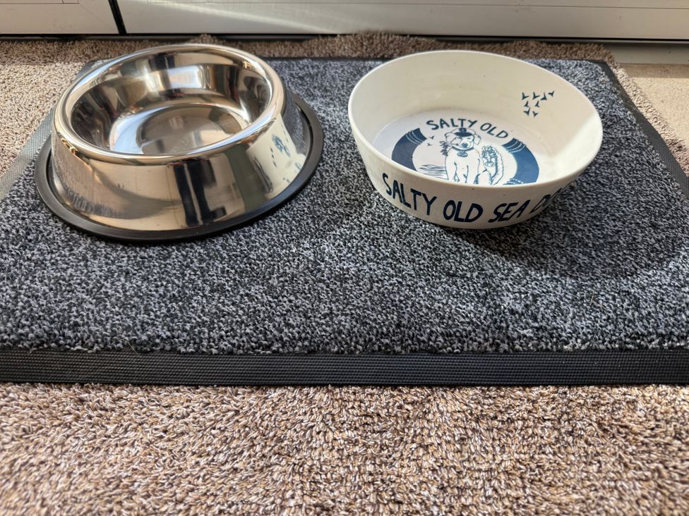 A dog bowl and a pet bowl on a mat at York Cottage in Southwold