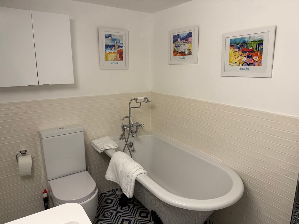 A bathroom with bathtub and toilet at York Cottage Southwold