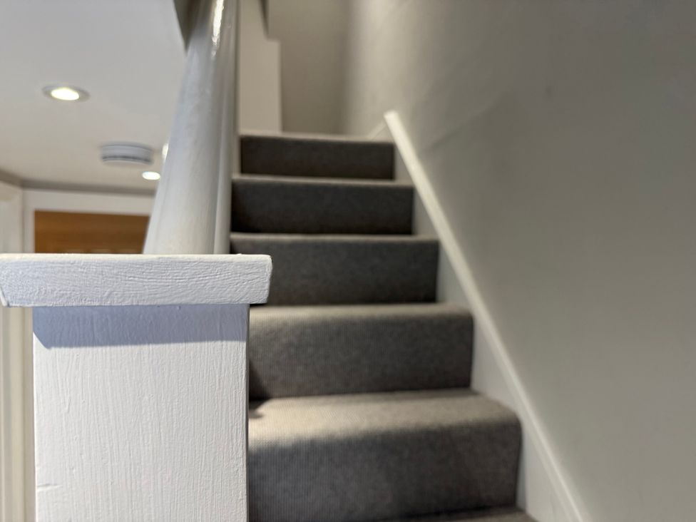 A staircase with a carpet and handrail at York Cottage Southwold