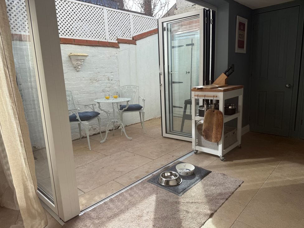 An indoor kitchen with a serving cart and seating area at York Cottage Southwold