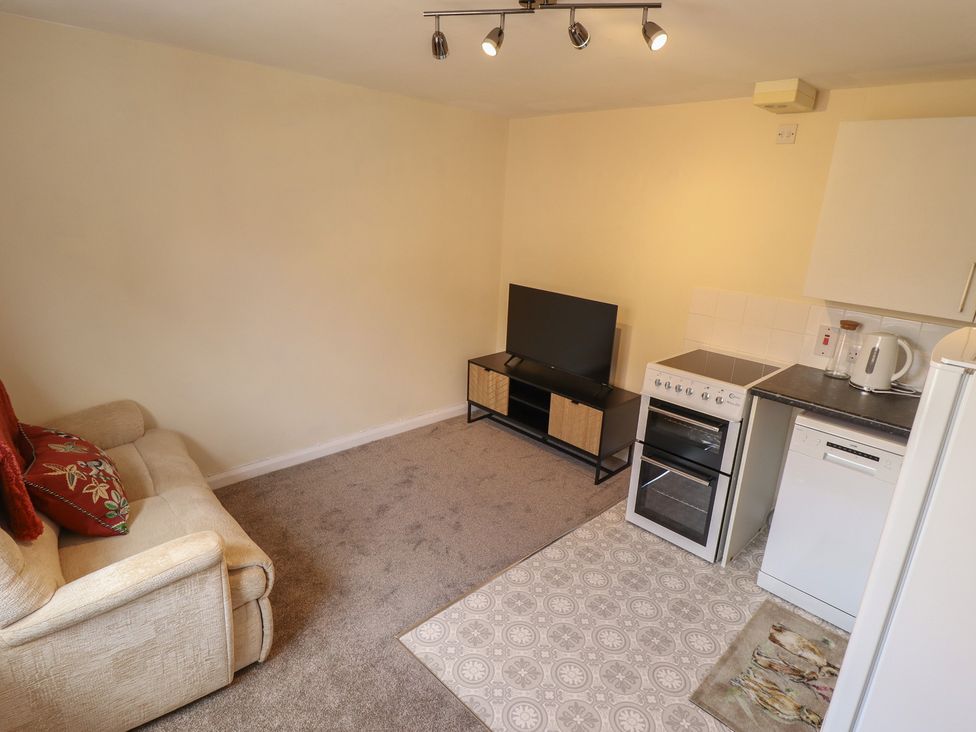A living room with a sofa and television stand at 29B High Street in Spilsby