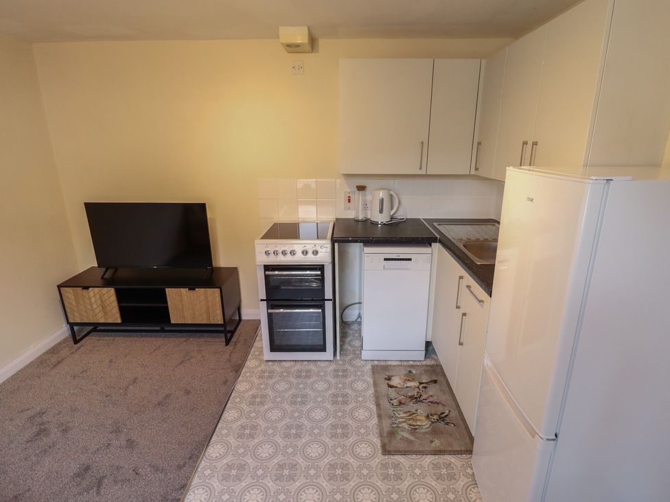 A kitchen with appliances and a television at 29B High Street in Spilsby