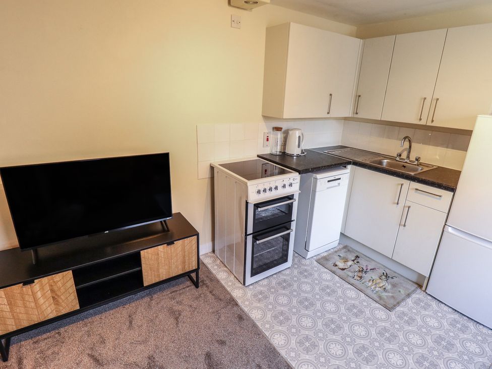 A kitchen with appliances and a television at 29B High Street in Spilsby