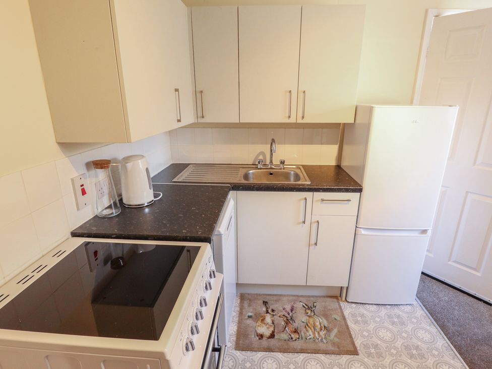 A kitchen with sink, stove, refrigerator and kettle at 29B High Street in Spilsby