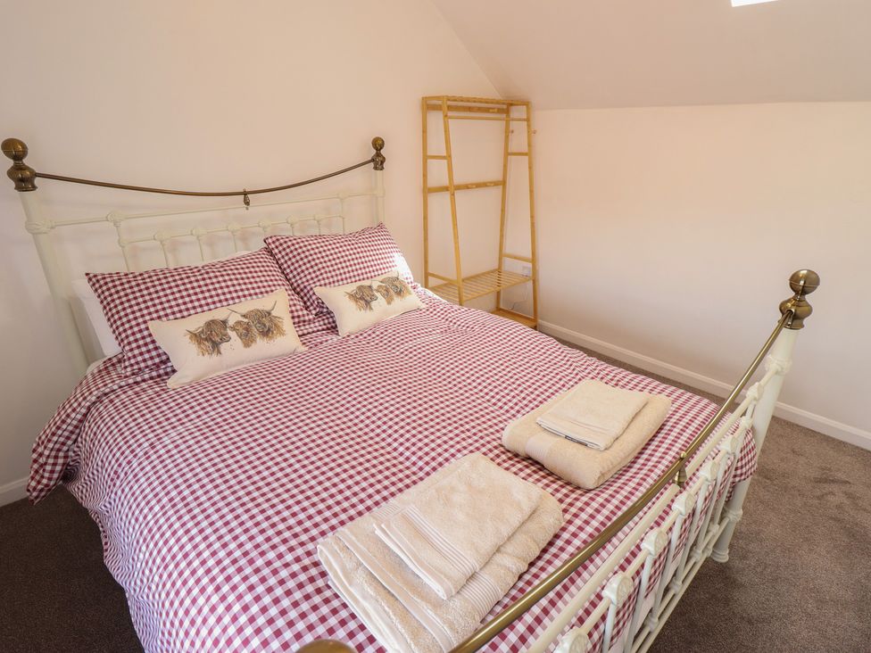 A bedroom with a bed and towels at 29B High Street in Spilsby