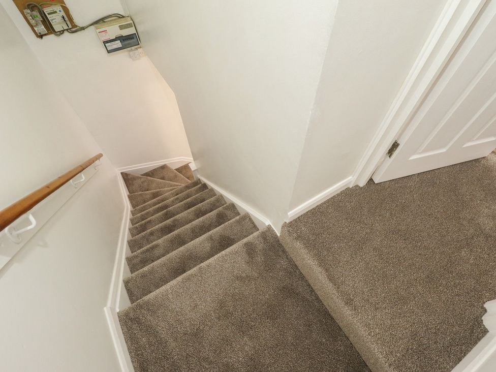 A staircase with a handrail and electrical panel at 29B High Street in Spilsby