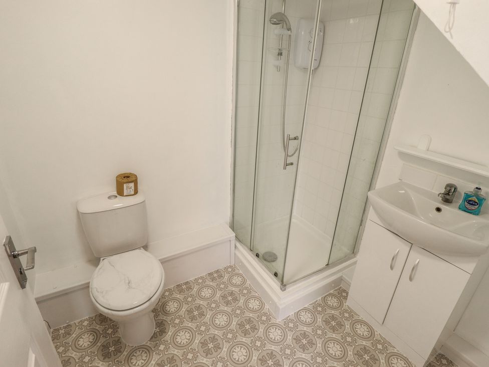 A bathroom with a toilet, shower, and sink at 29B High Street in Spilsby