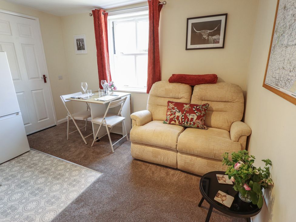 A living room with a sofa and dining area at Goldfinch in Spilsby