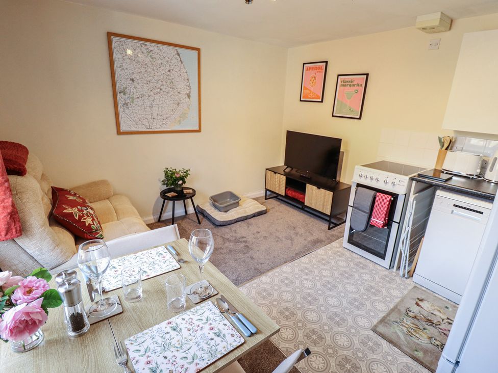 A living room with a sofa, dining table and kitchen appliances at Goldfinch in Spilsby