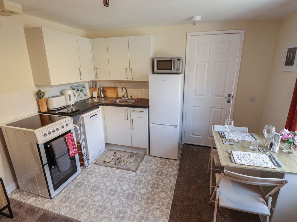 A kitchen with appliances and dining table at Goldfinch in Spilsby
