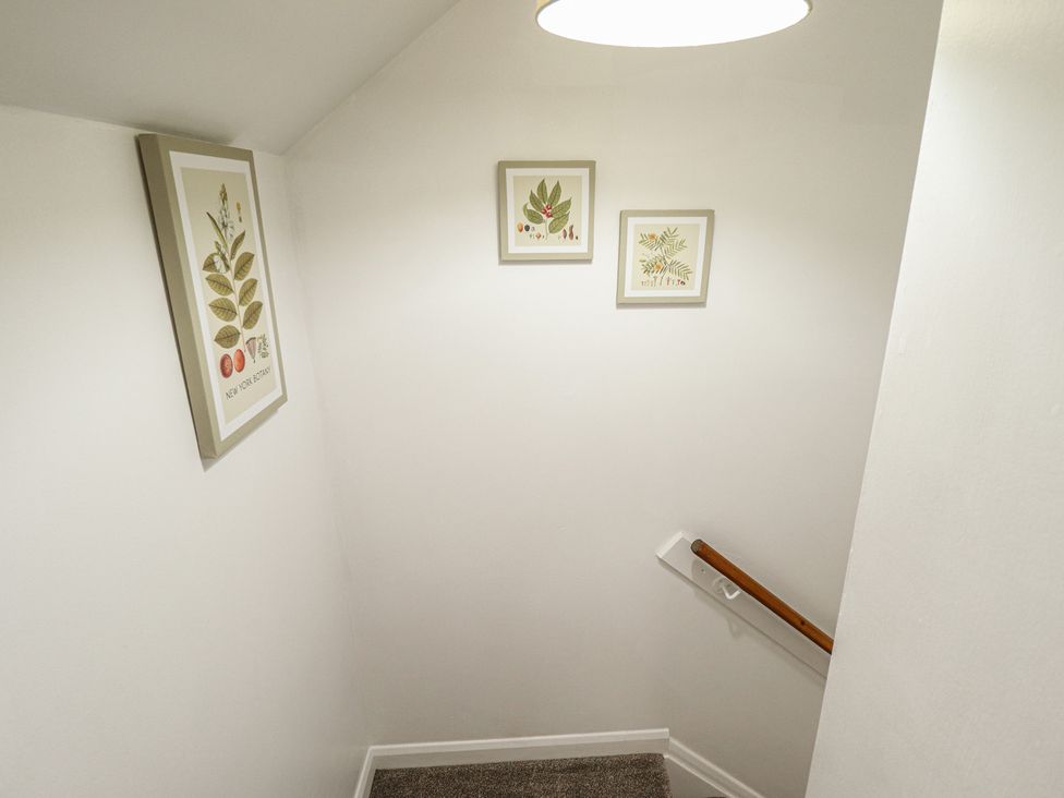A staircase with framed artwork on the wall at Goldfinch in Spilsby