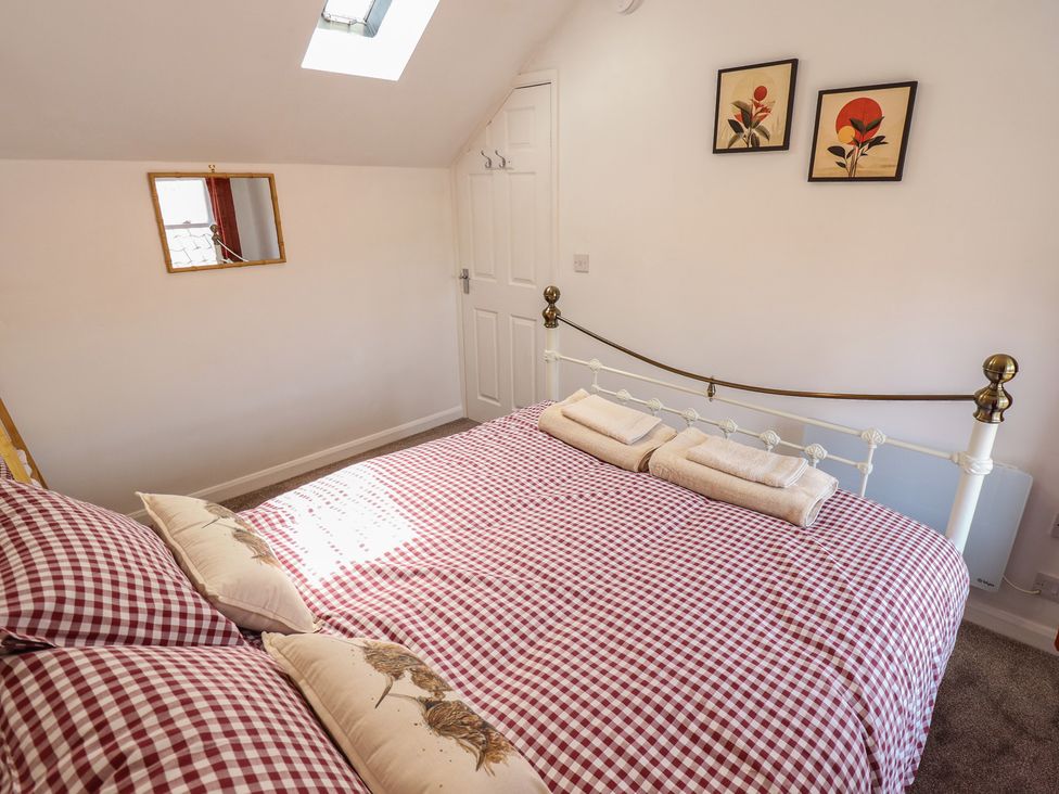 A bedroom with a bed and wall art at Goldfinch in Spilsby
