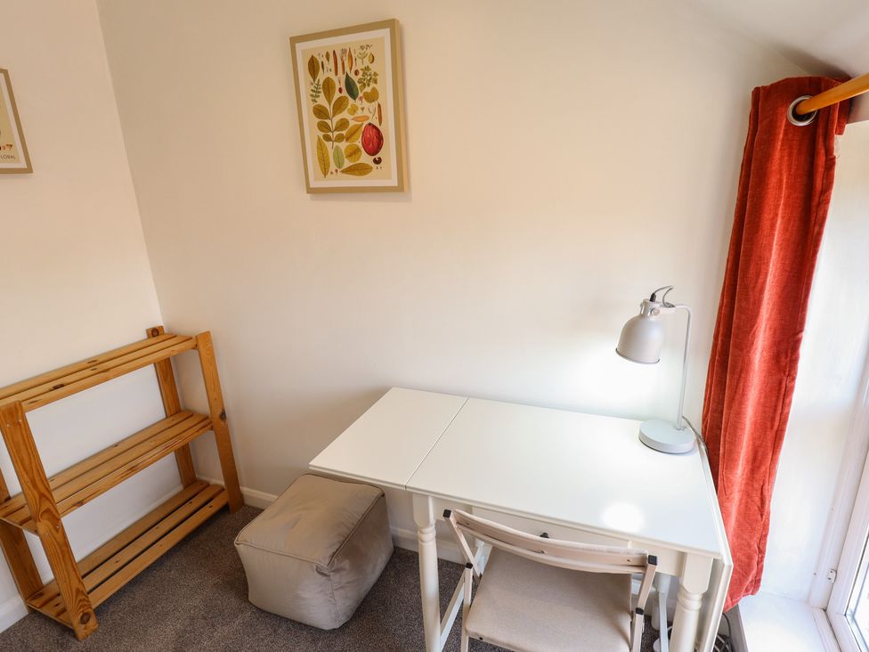 An office with a desk, chair, and lamp at Goldfinch in Spilsby