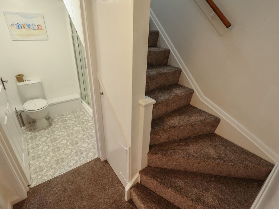 A bathroom with a toilet and shower along the staircase at Goldfinch in Spilsby